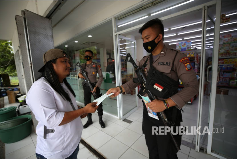 Aparat Kepolisian dari Satuan Samapta Polda Sulawesi Tengah melakukan pendampingan pengamanan kegiatan jual beli toko retail dan SPBU yang berada di wilayah Martadinata, Mamuju, Sulawesi Barat (Sulbar), Selasa (19/1).