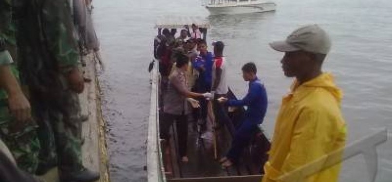 Aparat Kepolisian dibantu warga mengevakuasi jenasah yang menjadi korban jatuhnya pesawat Merpati MA-60 PK di Kaimana, Papua Barat, Ahad (8/5).