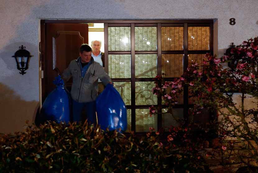 Aparat kepolisian Jerman mengangkut dua kantung plastik warna biru dari rumah orang tua copilot Germanwings, Andreas Lubitz, di Montabaur, Jerman, Kamis (26/3).