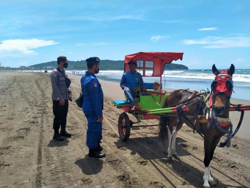 Aparat kepolisian melakukan patroli di kawasan Pantai Pangandaran. Diharapakan, dengan pelonggaran syarat perjalanan, pantai Pangandaran kembali diramaikan pengunjung.
