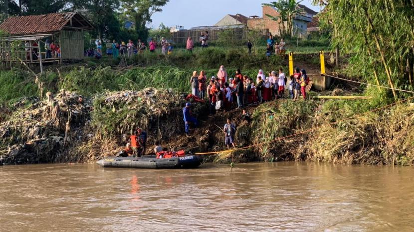 Aparat kepolisian membantu siswa menyeberang Sungai Cimanuk di wilayah Kecamatan Karangpawitan, Kabupaten Garut, menggunakan perahu karet, Senin (18/7/2022). Pasalnya, jembatan yang berada di wilayah itu rusak terdampak banjir bandang.