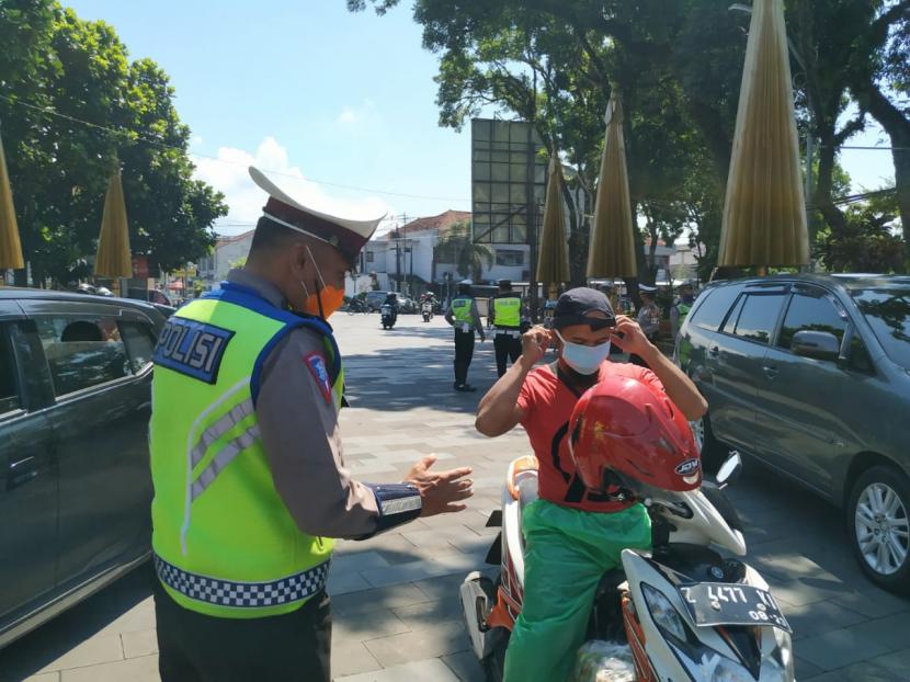 Aparat kepolisian memberhentikan pengguna jalan yang kedapatan tidak menggunakan masker di Taman Kota Tasikmalaya, Kamis (9/4). Masyarakat yang tidak memakai masker diberi edukasi mengenai virus corona dan selanjutnya dibagikan masker untuk digunakan.