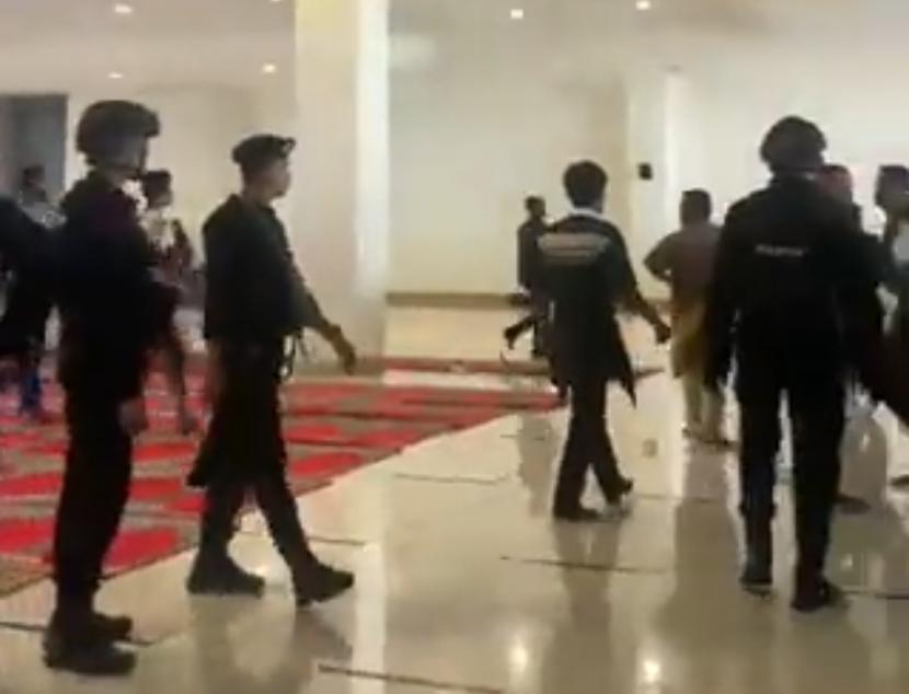 Aparat kepolisian membubarkan warga Air Bangis di Masjid Raya Sumbar, Sabtu (5/8/2023), dengan tetap memakai sepatu di area suci. Saksi mata sebut polisi masuk tanpa membuka sepatu dan bawa senjata.