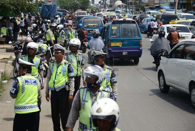  Aparat kepolisian memeriksa kelengkapan surat kendaraan pengendara motor saat menggelar operasi Zebra Jaya 2014 di Jalan Margonda Raya, Depok, Jumat (28/11).    (Republika/Raisan Al Farisi)
