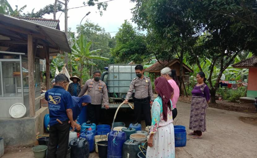 Aparat kepolisian mendistribusikan air bersih untuk warga terdampak kekeringan di Kecamatan Cineam, Kabupaten Tasikmalaya, Jumat (7/8).