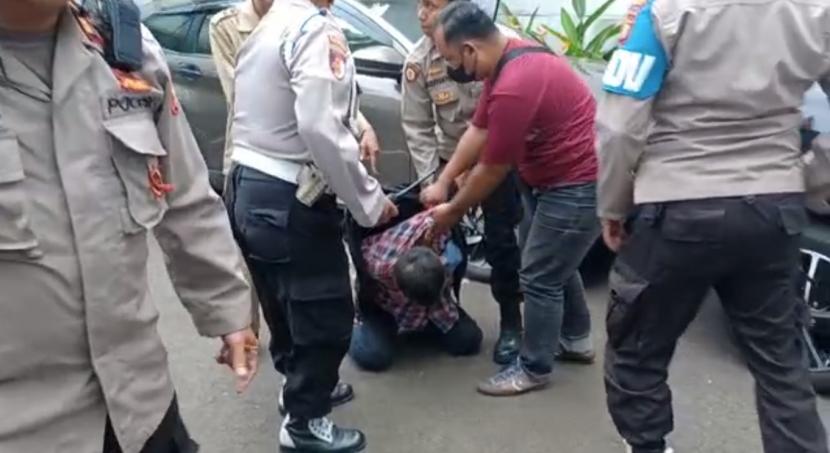 Aparat kepolisian mengamankan seorang pria yang diduga pelaku penembakan di Kantor Majelis Ulama Indonesia (MUI) di Jalan Proklamasi, Jakarta Pusat, pada Selasa (2/5/2023) siang. 