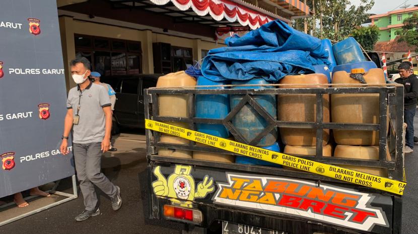 Aparat kepolisian menggiring dua orang tersangka penimbunan BBM di Polres Garut, Rabu (7/9/2022). 