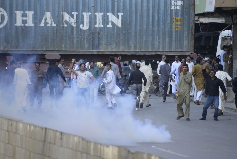 Aparat kepolisian Pakistan melepaskan tembakan gas air mata ke arah demonstran di Rawalpindi, Pakistan, 28 October 2016. 