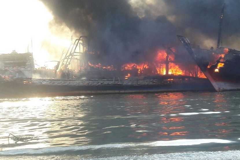 Api berkobar di sejumlah kapal nelayan yang terbakar di aliran sungai Silugonggo, KecamatanJuwana, Kabupaten Pati, Sabtu (15/7).