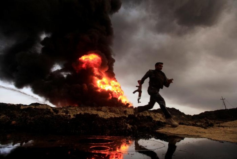 Api dan asap membumbung dari sumur minyak yang dibakar militan ISIS di Qayyara, Irak, 4 November 2016.