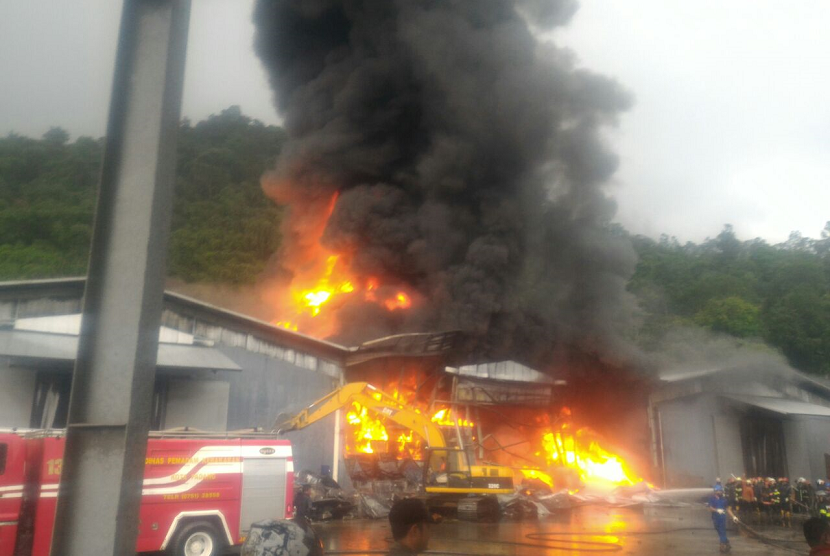 Api melahap gudang milik PT Incasi Raya di Lubuk Begalung, Padang, Sumbar, pada Senin (23/4). Petugas masih berupaya memadamkan api yang sudah berkobar selama lebih dari 6 jam. 