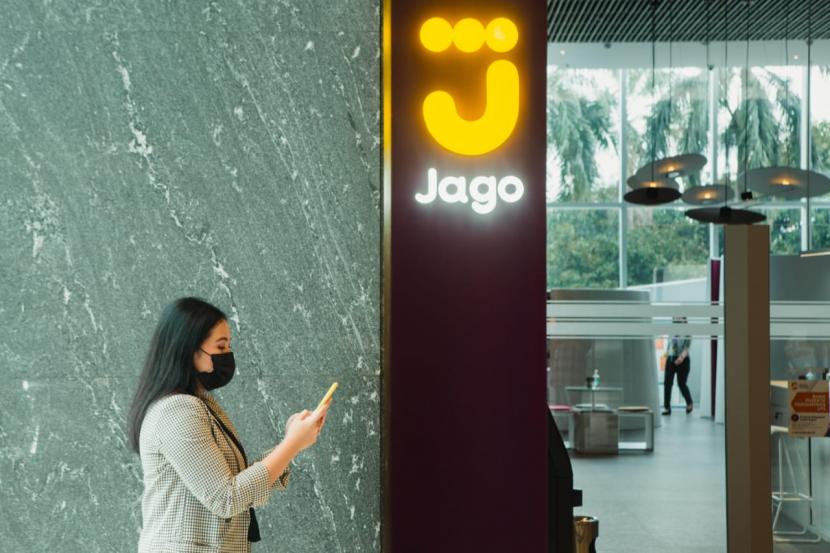 Seorang pengunjung melintas di depan logo Bank Jago, Kamis (15/4). Hingga akhir Juni 2021, Bank Jago telah menyalurkan kredit Rp 2,17 triliun, tumbuh 695 persen dari posisi yang sama tahun lalu.  