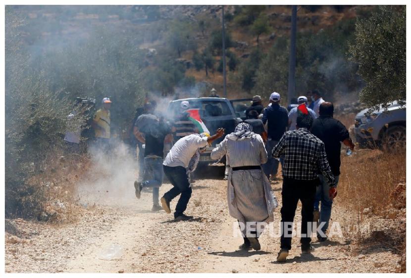  Warga Palestina melempari batu ke arah pasukan pendudukan Israel, saat unjuk rasa menentang pencaplokan tanah Palestina oleh Israel di Tepi Barat. Sembilan Negara Uni Eropa Tolak Label Teroris LSM Palestina Bikinan Israel 