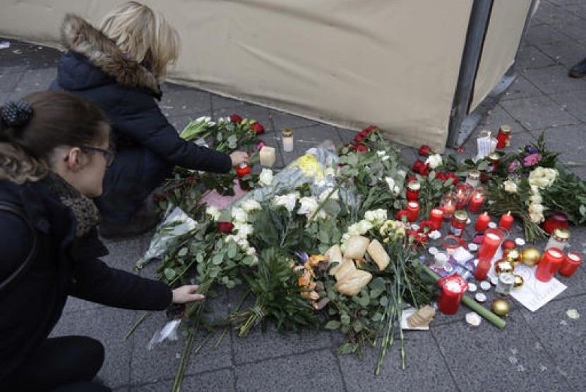 arga meletakkan bunga dekat lokasi truk yang menabrak kerumunan orang di pasar Natal di Berlin, Jerman, Selasa, 20 Desember 2016.
