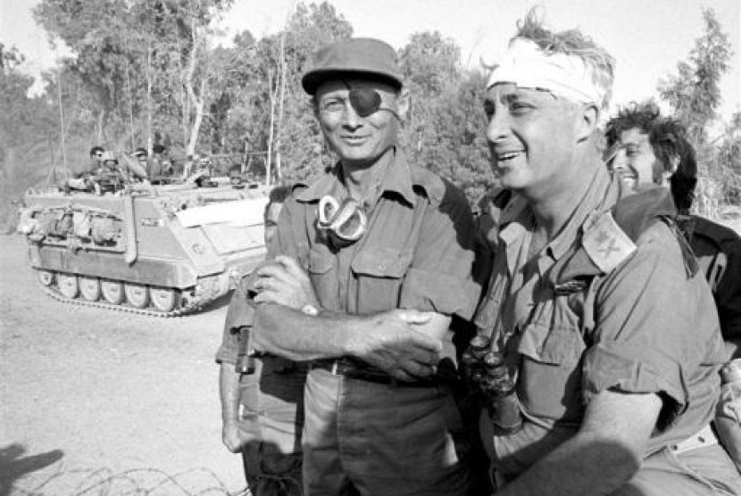 Ariel Sharon (right), his head bandaged after an injury, stands with Moshe Dayan (left) on the western side of the Suez Canal in 1973 war. This photo became an iconic image of the conflict. (File photo)