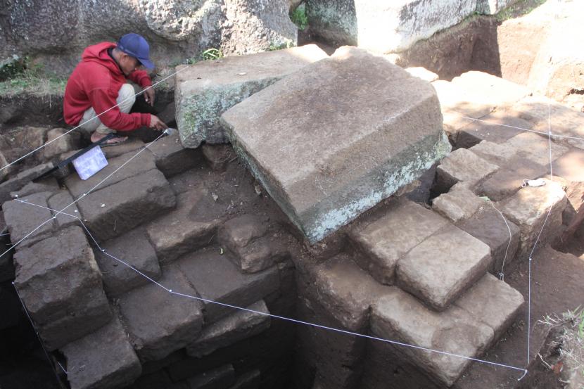 Arkeolog dari Balai Pelestarian Cagar Budaya (BPCB) Jawa Timur membersihkan struktur batu kuno yang ditemukan saat dalam ekskavasi di situs Arca Dwarapala, Singosari, Malang, Jatim, Senin (4/7/2022). Dalam ekskavasi tersebut arkeolog juga menemukan struktur batu dari abad 12 Masehi. 