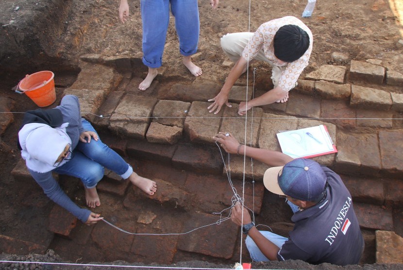 Arkeolog dari tim Balai Pelestarian Cagar Budaya (BPCB) Trowulan melakukan eskavasi pada struktur bata kuno yang ditemukan di Situs Pendem, Batu, Jawa Timur, Sabtu (14/12).