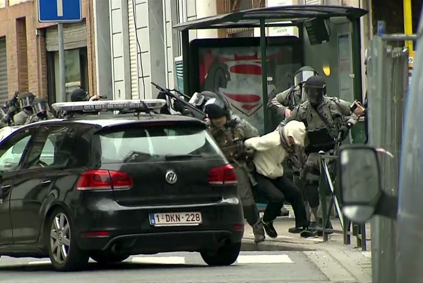 Armed Belgian police apprehend a suspect, in this still image taken from video, in Molenbeek, near Brussels, Belgium, March 18, 2016. 