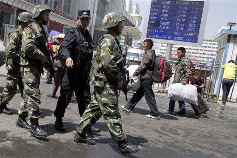 Armed Chinese paramilitary policemen march past the site of the explosion outside the Urumqi South Railway Station in Urumqi, Xinjiang Uygur Autonomous Region, in May this year. (File)