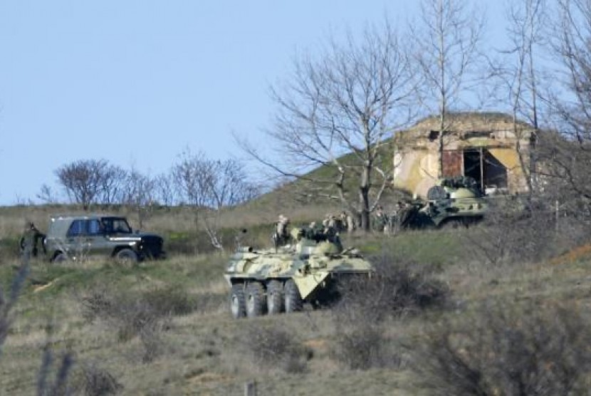 Armed men, believed to be Russian servicemen, gather on a hill near a military base in the Crimean town of Belbek outside Sevastopol March 22, 2014. 