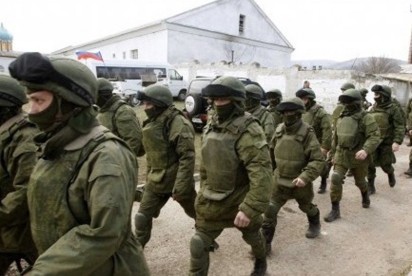 Armed men, believed to be Russian servicemen, walk outside a Ukrainian military base in Perevalnoye, near the Crimean city of Simferopol, March 14, 2014