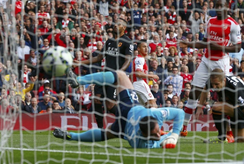 Arsenal's Alexis Sanchez (C) scores a goal against Hull during their English Premier League soccer match at the Emirates stadium in London October 18, 2014.