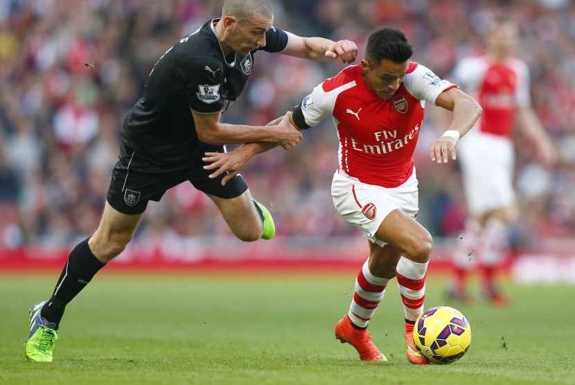 Arsenal's Alexis Sanchez (R) is challenged by Burnley's David Jones during their English Premier League soccer match at the Emirates Stadium in London November 1, 2014.