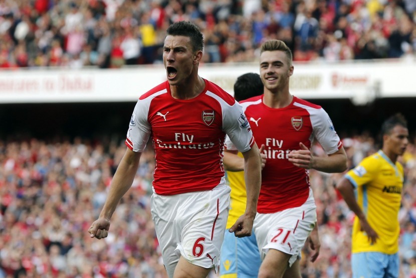 Arsenal's Laurent Koscielny (front) celebrates after scoring against Crystal Palace during the English Premier League soccer match at the Emirates stadium in London August 16, 2014. 