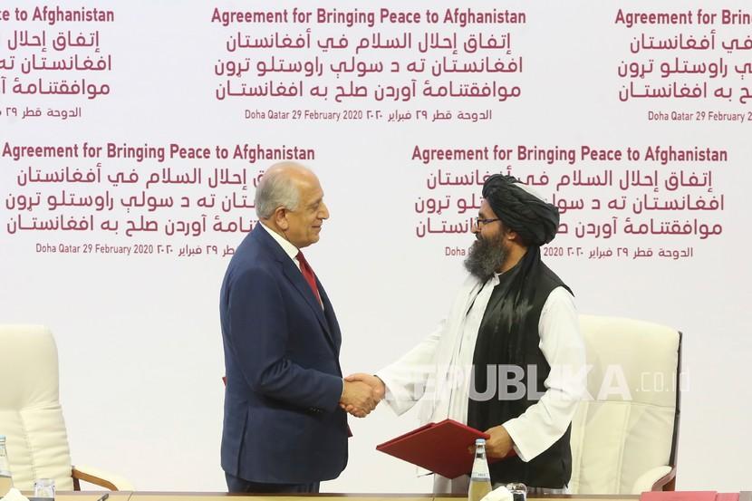 ARSIP - Dalam foto arsip 29 Februari 2020 ini, utusan perdamaian AS Zalmay Khalilzad, kiri, dan Mullah Abdul Ghani Baradar, pemimpin politik utama kelompok Taliban berjabat tangan setelah menandatangani perjanjian damai antara Taliban dan pejabat AS di Doha, Qatar. 