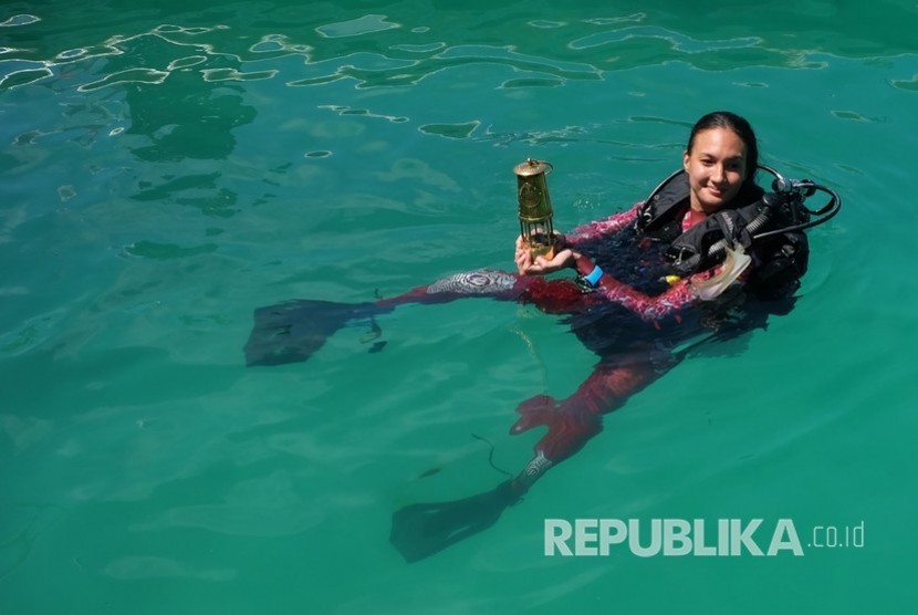 Artis Nadine Chandrawinata berenang sambil membawa obor Asian Games 2018 di perairan Raja Ampat, Papua Barat, Kamis (26/7).