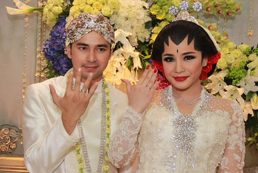 Artis sekaligus presenter Raffi Ahmad (kiri) bersama istri Nagita Slavina (kanan) menunjukan cincin seusai akad nikah di Jakarta, Jumat, (17/10). 