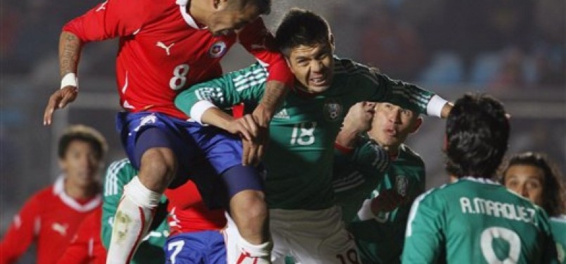Arturo Vidal (kiri), pemain timnas Cile, melepaskan sundulan untuk membawa Cile menang 2-1 atas Meksiko.
