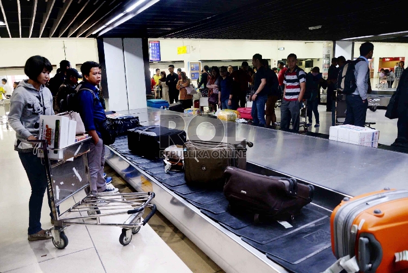 Penumpang menunggu barang bawaan mereka di terminal kedatangan 1C Bandara Internasional Soekarno Hatta, Tangerang, Banten, Rabu (22/7). (Republika/Yasin Habibi)  