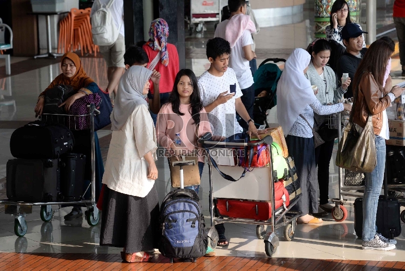 Penumpang menunggu barang bawaan mereka di terminal kedatangan 1C Bandara Internasional Soekarno Hatta, Tangerang, Banten, Rabu (22/7). (Republika/Yasin Habibi)