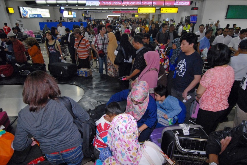 Arus Balik Bandara Soekarno-Hatta. Sejumlah penumpang menunggu barang bawaan mereka di terminal kedatangan 2F Bandara Internasional Soekarno Hatta, Tangerang, Banten, Selasa (21/7).