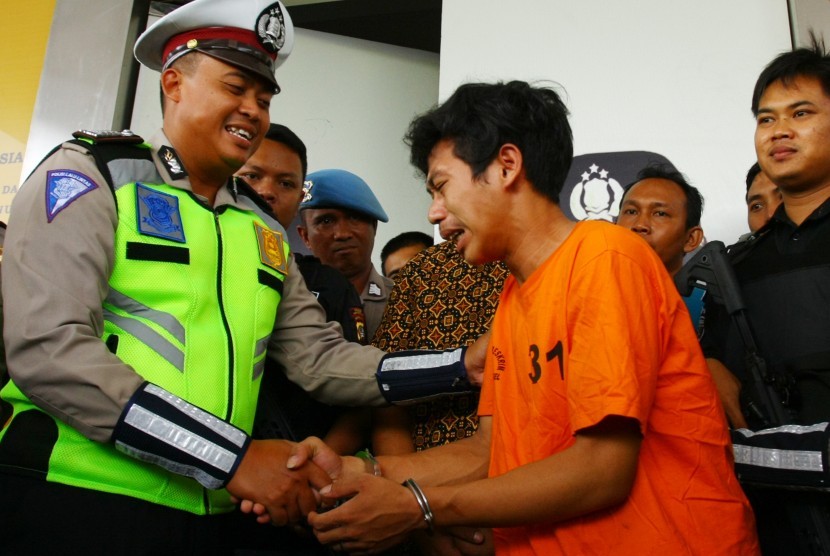AS, pemuda yang merusak motornya sendiri saat kena tilang, menangis saat meminta maaf kepada Bripka Oky (kiri) Polantas yang dimaki-makinya saat menilang, di Mapolres Tangerang Selatan, Banten, Jumat (8/2/2019). 