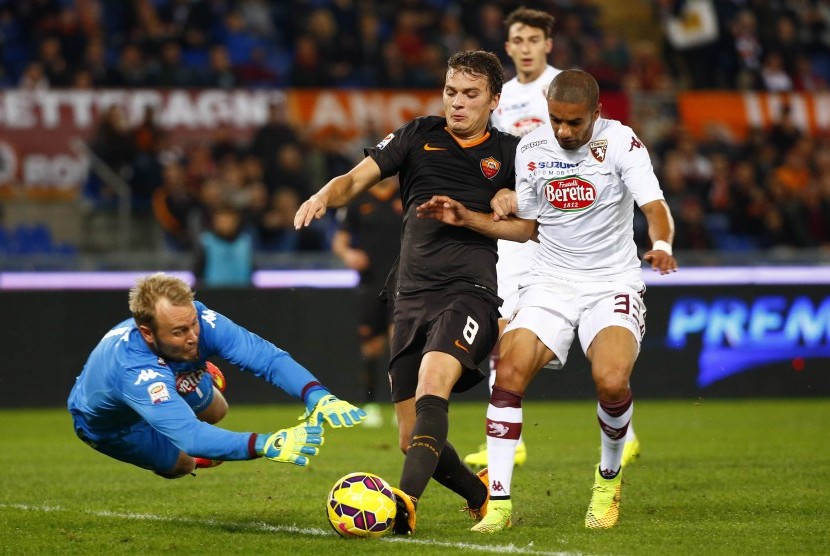 AS Roma's Adem Ljajic (C) is challenged by Torino's goalkeeper Jean Francois Gillet (L) and Bruno Peres during their Italian Serie A soccer match at the Olympic stadium in Rome November 9, 2014