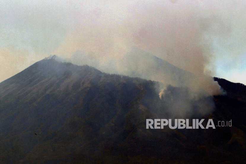 Asap membubung dari lokasi kebakaran hutan di lereng Gunung Arjuno terlihat dari Desa Landungsari, Malang, Jawa Timur, Jumat (11/10/2019).