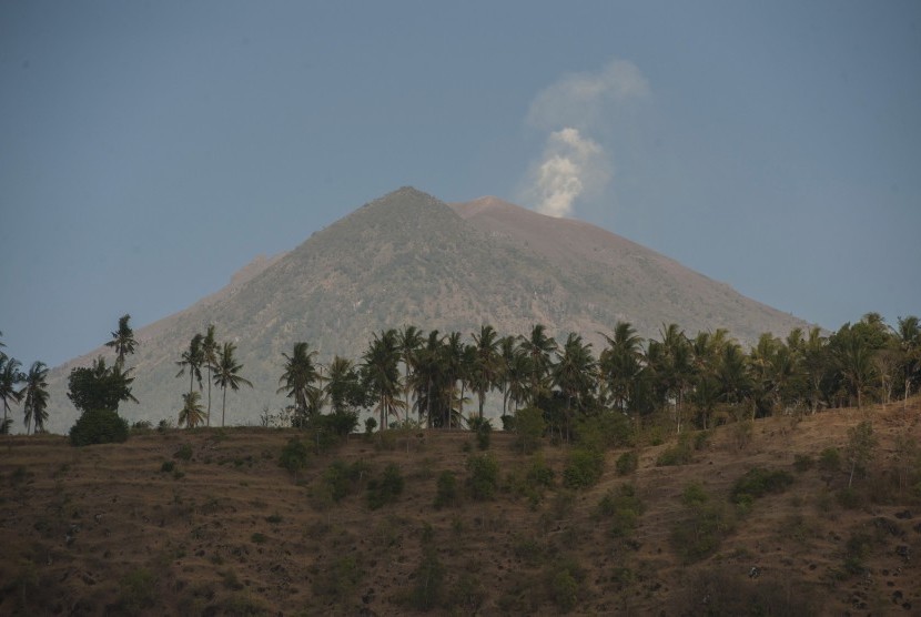 Asap mengepul dari kawah Gunung Agung yang berstatus awas terlihat dari Desa Amed, Karangasem, Bali, Jumat (29/9). 