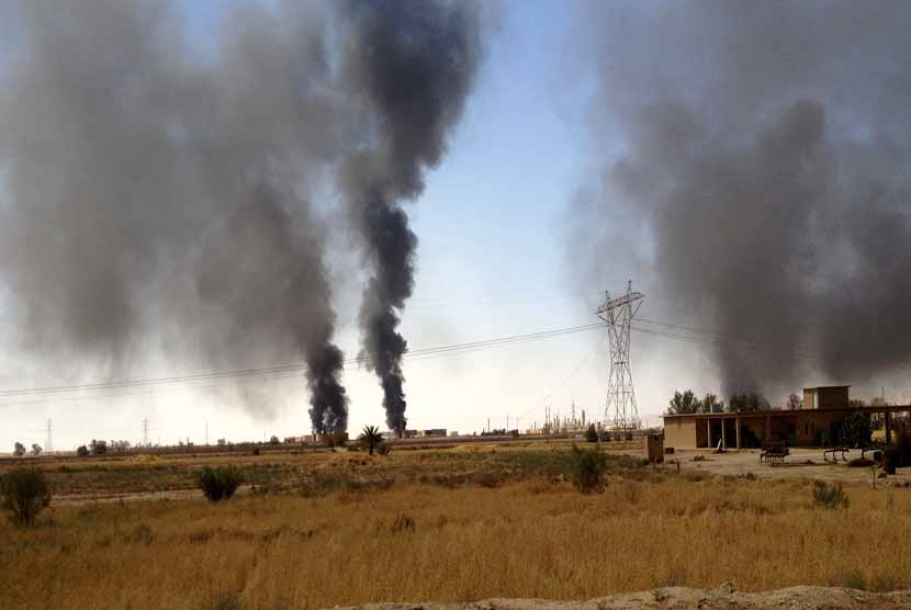 Asap mengepul dari kilang minyak yang terbakar saat bentrokan terjadi antara gerilyawan ISL dan tentara pemerintah di Baji, Irak, pada 30 Juli lalu.