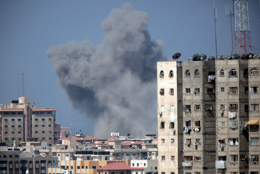   Asap mengepul di kota Gaza, Jumat (8/8), akibat serangan militer Israel setelah gencatan senjata selama tiga hari berakhir.