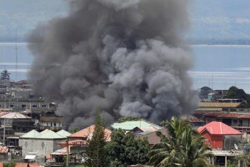 Asap mengepul di permukiman di Kota Marawi akibat pertempuran antara pasukan pemerintah dan kelompok militan Maute di Filipina, 27 Mei 2017.