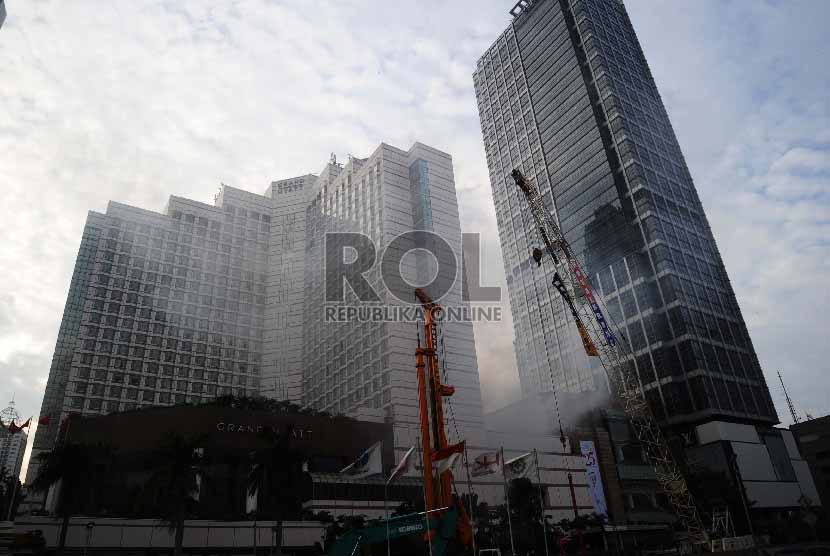 Asap mengepul diantara gedung saat terjadi kebakaran di Grand Hyatt, Jakarta, Sabtu (21/2). 