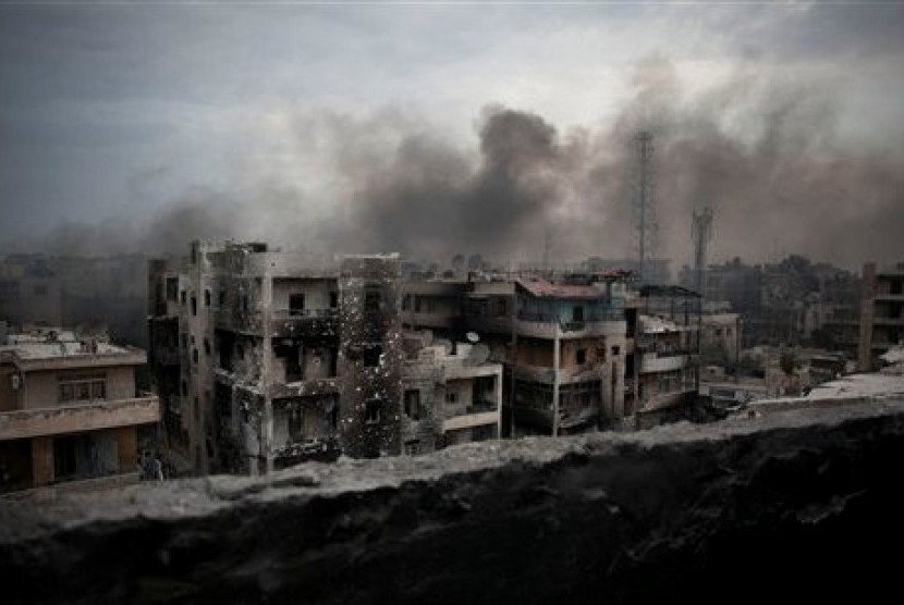 Asap pekat membubung di sejumlah apartemen yang terkena serangan bom di kawasan Distrik Saif Ad-Daulah di Aleppo, Suriah.