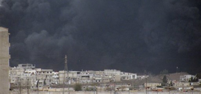 Asap tebal dan hitam pekat membubung di langit Kota Homs, Suriah, beberapa waktu lalu.