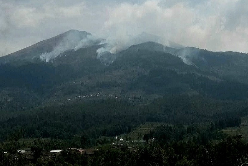 Asap tebal masih mengepul di lereng utara gunung Merbabu, di lihat dari wilayah Kecanatan Getasan, Kabupaten Semarang, Selasa (16/10). Gunung Merbabu terbakar sejak Ahad (14/10) siang dan hibgga hari ini api masih terus berkobar.