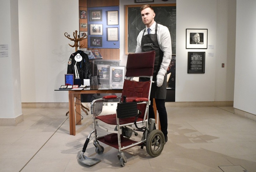 Asisten galeri memperlihatkan kursi roda bermotor milik Profesor Stephen Hawking dari tahun 1988 dalam lelang di Christies Auction House, London, Inggris, (30/10).