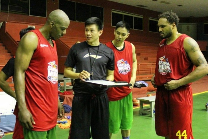 Asisten pelatih Satria Muda Pertamina Youbel Sondakh (hitam) memberikan instruksi kepada Tiras Wade (kiri) disaksikan oleh Dior Lowhorn (kanan) dan Rony Gunawan (kedua kanan).
