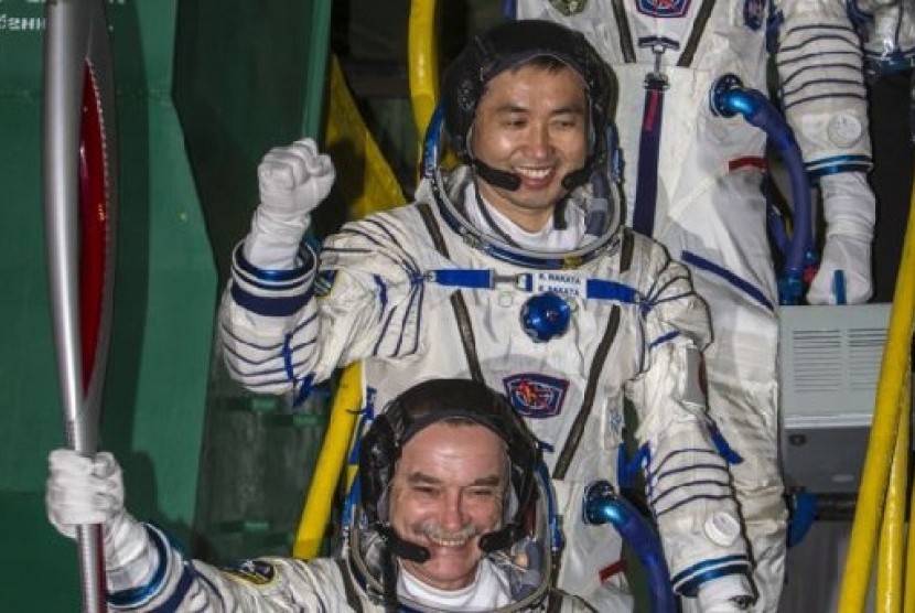 Astronot Jepang Koichi Wakata (tengah), kosmonot Rusia Mikhail Tyurin (membawa obor) dan Astronot AS Rick Mastracchio (atas, tidak terlihat) membawa obor Olimpiade dengan roket Soyuz-FG dari kosmodrome Baikonur, Kazakhstan, menuju ISS (7/11).