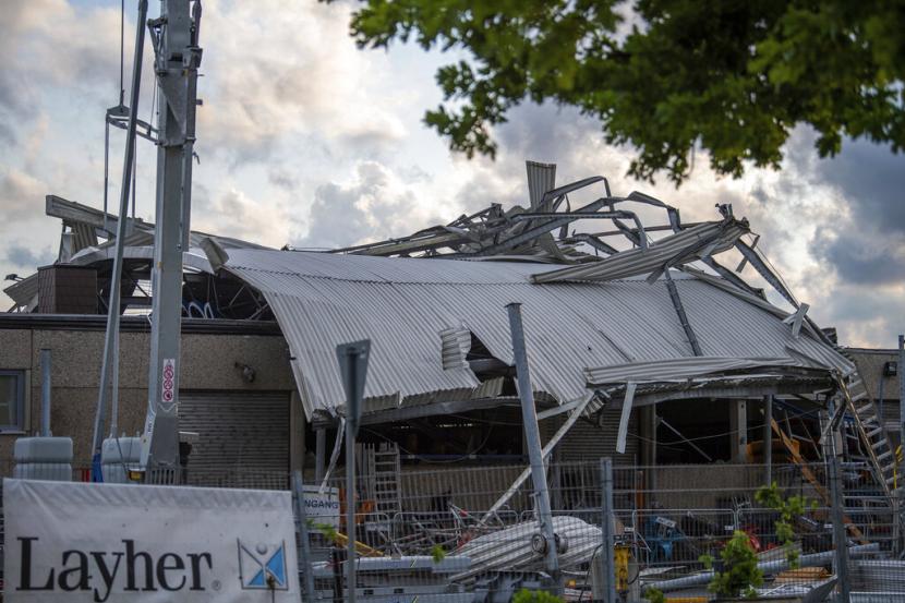Atap dealer mesin konstruksi terletak di seberang gedung saat badai di Paderborn, Jerman, Jumat, 20 Mei 2022. Tornado menyapu kota Paderborn di Jerman barat pada hari Jumat, melukai sedikitnya 30 orang saat menerbangkan atap, menumbangkan pohon dan mengirim puing-puing terbang bermil-mil, kata pihak berwenang.